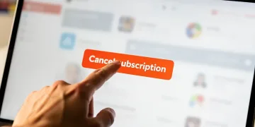 Hand clicking 1-click cancel subscription button on a tablet screen
