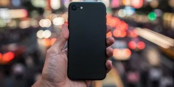 Minimalist phone held by a person in a busy urban setting, symbolizing digital detox